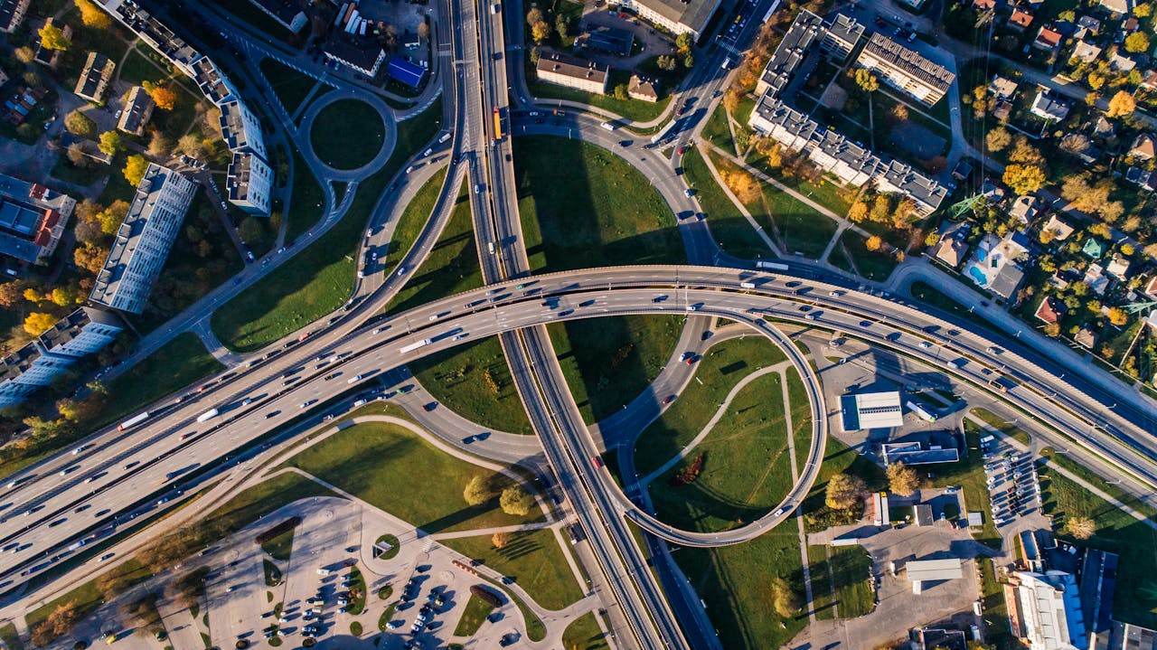 about-us Aerial shot of a complex highway intersection in a vibrant urban cityscape.